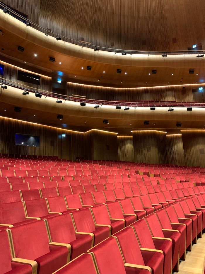Elegant empty auditorium with red velvet seats in Istanbul, perfect for concerts or lectures.