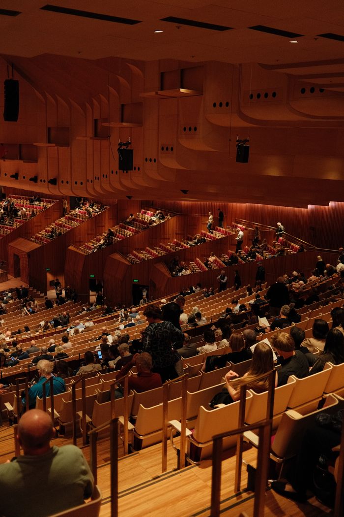 View from above of an audience gathering in the iconic Sydney Opera House Concert Hall.